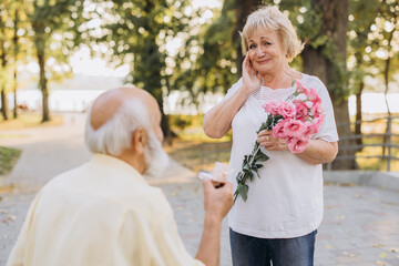 Senior Gentleman Making Proposal To Happy Excited Lady Outdoors