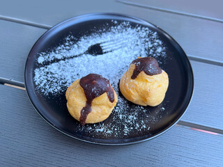Eclairs with vanilla cream in a back  plate 