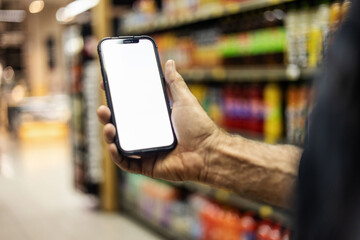 Closeup shot of a man checking his digital shopping list on his cellphone in a grocery store....