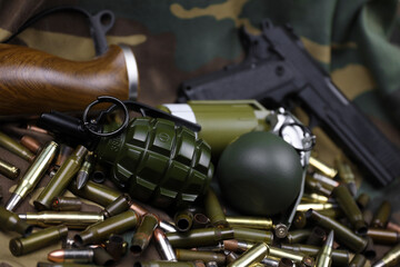 Different types of ammunition and grenades on a camouflage background. Preparing for war....
