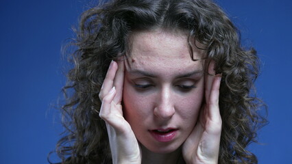 Stressed overwhelmed young woman trying to sooth her nervousness by putting hands on the side of...