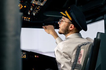 Airplane cabin The pilot checks the plane's electronics by pressing the buttons Preparing the...