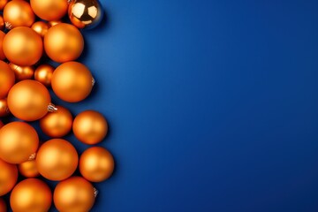  a bunch of orange christmas balls on a blue background with a gold ornament hanging from the top of one of them.