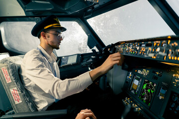 young pilots in the cockpit of the plane control air transport during a long distance flight...