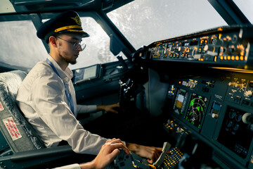 young pilots in the cockpit of the plane control air transport during a long distance flight simulator