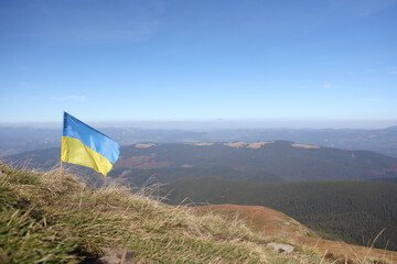 Ukrainian flag on top of Hoverla mountain in Ukraine close up