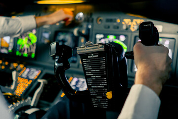 close-up Pilot in the cockpit of an airplane holding a rotary steering wheel during a flight Air travel concept - obrazy, fototapety, plakaty