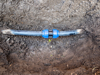 reparing water pipe damaged by shovel in ground when digging hole in garden with mechanical compression coupling