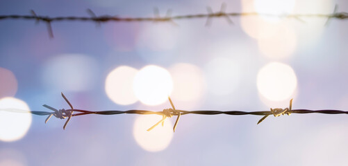 Barbed wire fence with sunset Twilight sky.