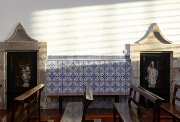 Church interior with portuguese handmade tiles and religious small statues. Azulejos portugueses