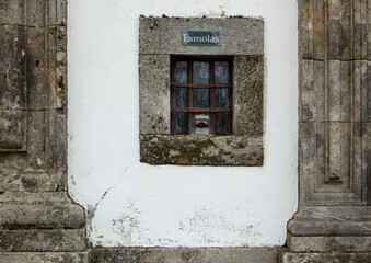 Church front facade with small window for donation or alms, esmolas in portuguese
