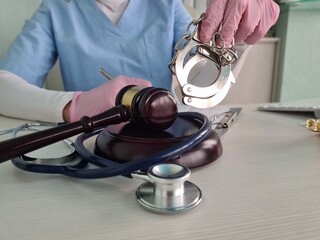 Doctor or judge hammer doctor stethoscope and handcuffs