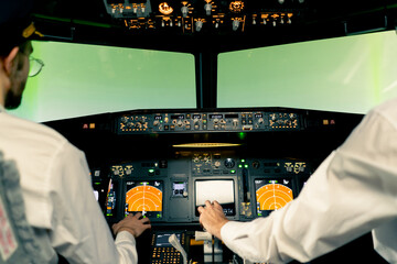 rear view of pilots in the cockpit of an airplane during flight control in a turbulence zone flight simulator