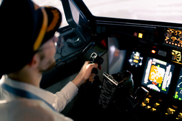 Pilot in the cockpit of an airplane holding a rotary steering wheel during a flight Air travel...