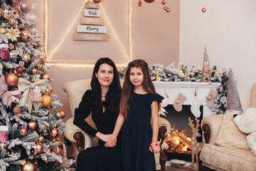 mom and daughter near the Christmas tree