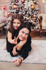 mom and daughter near the Christmas tree