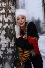 Woman with big braid in brown retro fur coat in winter street with snow. Winter cold weather. Girl...
