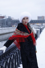 Woman with big braid in brown retro fur coat in winter street with snow. Winter cold weather. Girl...