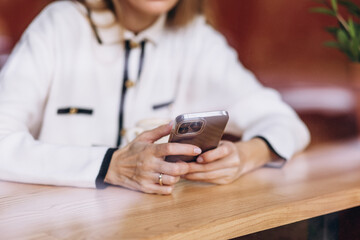 Woman sitting in coffee shop using mobile phone