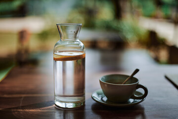 bottle of water and coffee on the table with nice bokeh and colors - 692016026