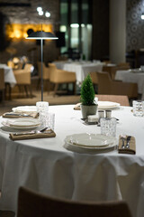 Restaurant table with cutlery and christmas tree.