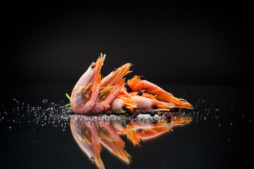 boiled shrimp with spices on black background