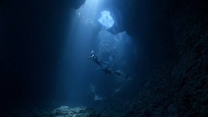 Fototapeta na wymiar SCUBA Divers explore an underwater cavern