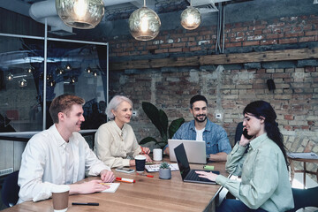 Smiling woman talking on the smartphone while sitting with her colleagues in the conference room. Teamwork, startup, strategy, business concept