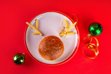 Christmas burger and french fries delivery menu. Big cheeseburger with french fries and ketchup sauce on festive Christmas and New Year decorated background