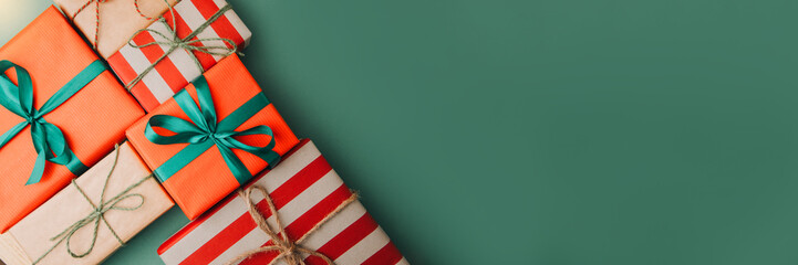 Christmas, festive background. Gifts wrapping in red and brown paper on a green background. Top view. Web banner
