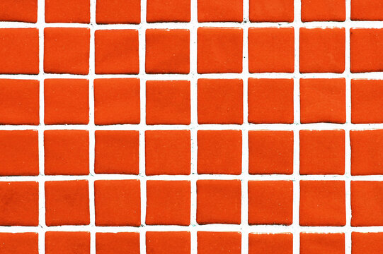 Orange square ceramic tile background. Swimming pool texture. Geometric wall decoration. Home bathroom floor. Ornamental patchwork. Simple square design. White fugue grid.