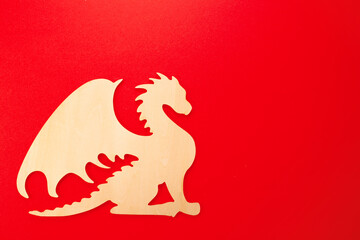Wooden drakon on red background. Chinese horoscope, new year of the dragon 2024