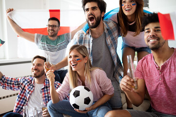 Young group of friends watching sport on television