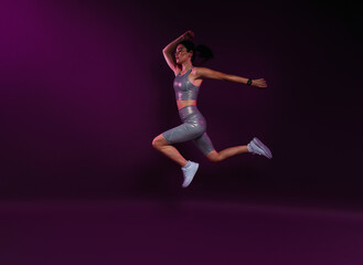 Side view of a slim sportswoman in silver fitness wear jumping against magenta background in studio