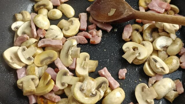 champignons de Paris et lardons de porc en cuisson dans une po&ecirc;le