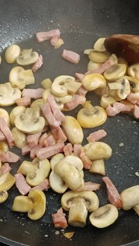 champignons de Paris et lardons de porc en cuisson dans une po&ecirc;le