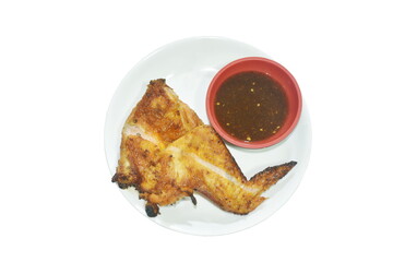 roasted chicken wing on plate dipping with spicy sauce