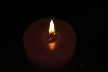 candle flame emerging in the darkness