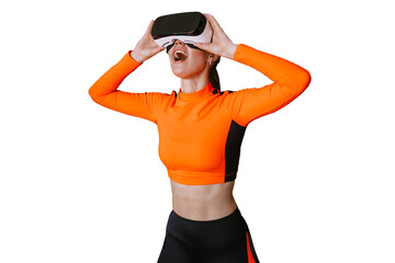 Excited young woman in orange sportswear using vr googles at gym surprised by technologies standing...