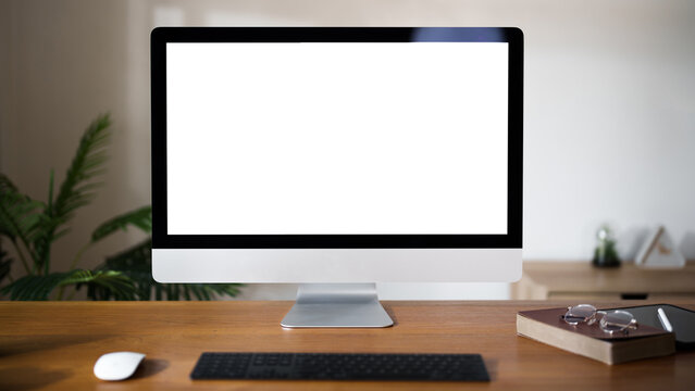 Front view of home office desktop computer with blank white screen for advertisement.