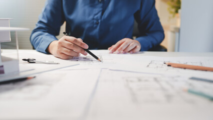 Architects interior designer hands working with Blue prints and documents for a home renovation for house design.