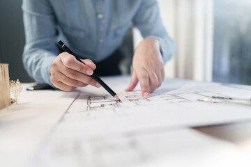 Architects interior designer hands working with Blue prints and documents for a home renovation for house design.