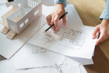 Architects interior designer hands working with Blue prints and documents for a home renovation for house design.