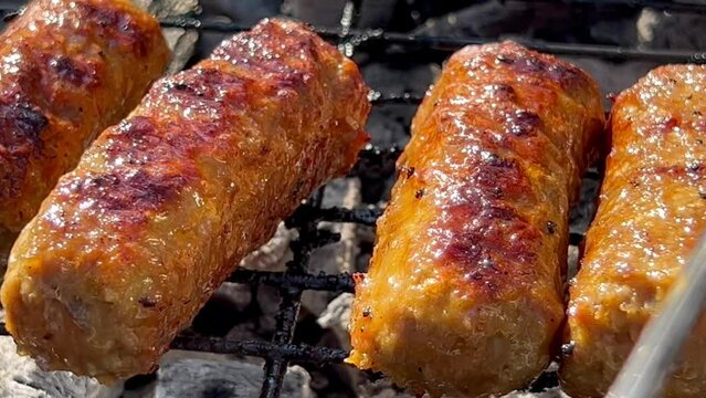 Ineg&ouml;l or Tekirdag Meatballs a type of grilled meat dish famous in Turkey made from minced lamb or beef Outdoor Close up. Man fries patties on barbecue. Meatballs on grill. Spicy minced meat rolls BBQ