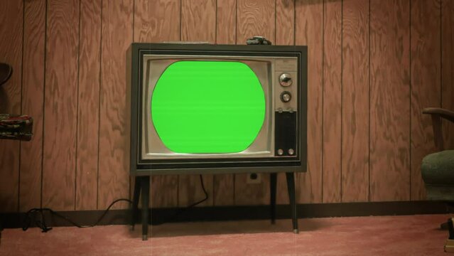 Vintage Television Green Screen Zoom In Retro TV Old House Film Texture. Old television with green screen, for replacement, inside a vintage house, zoom in. Old film texture