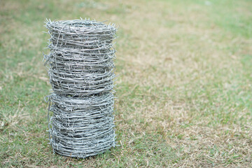 Rolls of barbed wire. Outdoor background. Concept, construction tool. Barbed wire is used for make fences , secure property ,make border to show the territory of area.                                 