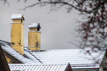 Gelbe Schornsteine auf schneebedecktem Dach
