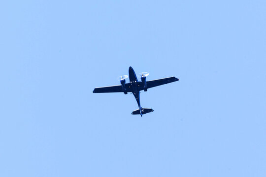 A twin-engine plane flying in a blue sky. Transportation. Aircraft. Trip.