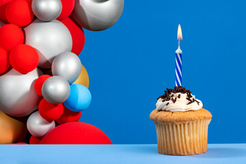 Birthday candle with cupcake on blue color background
