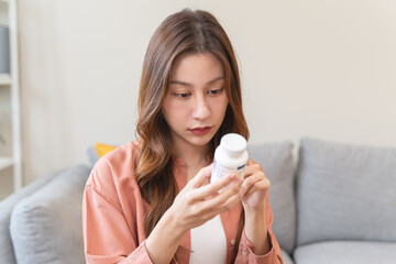 Girl reading vitamin supplement instruction and check warning suggestion information before eat.